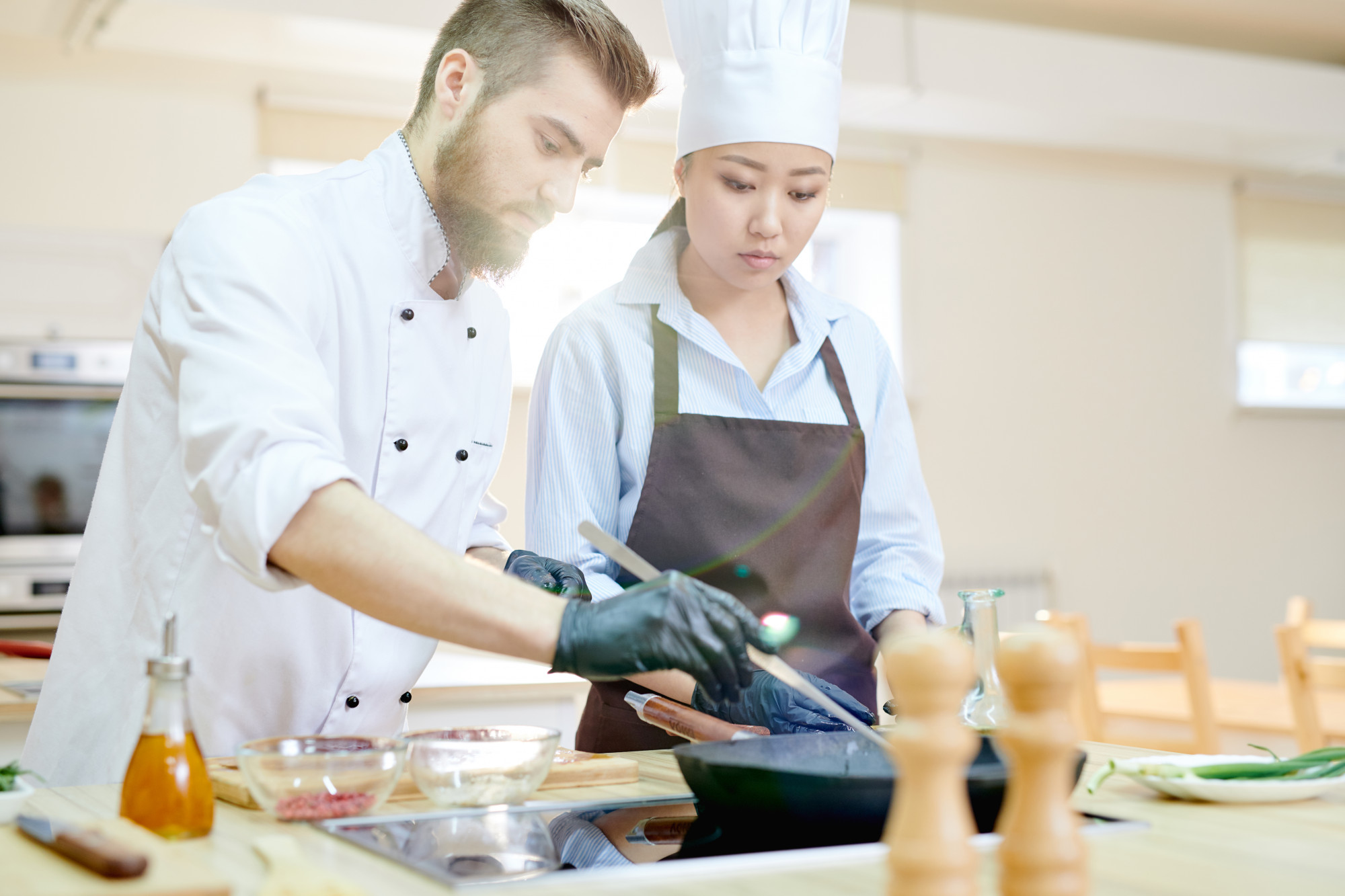 instruktor prowadzący warsztat kulinarny w kuchni restauracyjnej